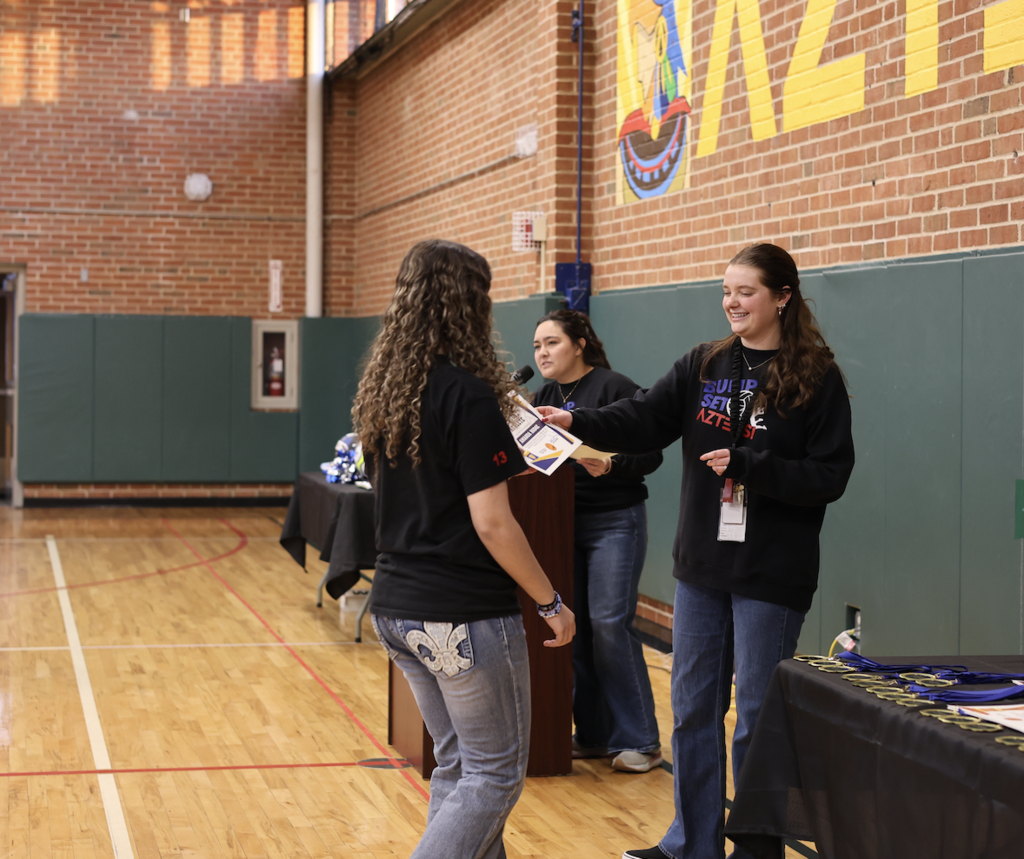 Ms. Vaughan giving a certificate to a student