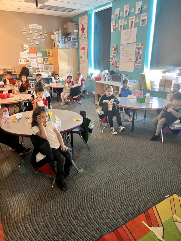 Children in their classroom eating popcorn — they were among the classes with the best attendance and received a popcorn party.
