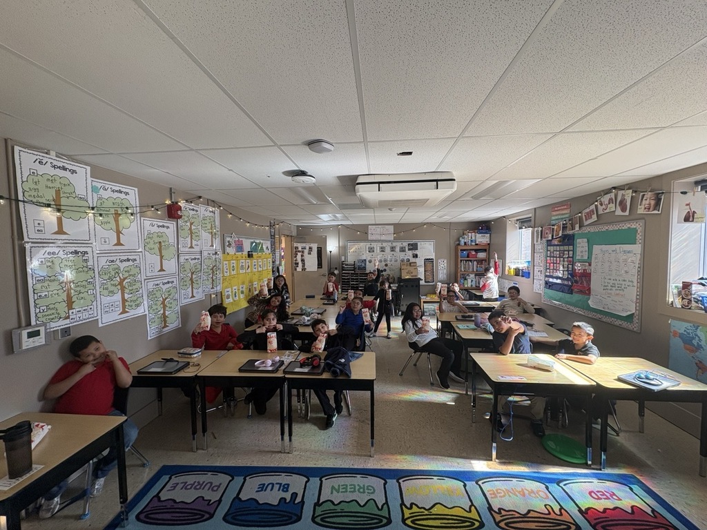 Children in their classroom eating popcorn — they were among the classes with the best attendance and received a popcorn party.