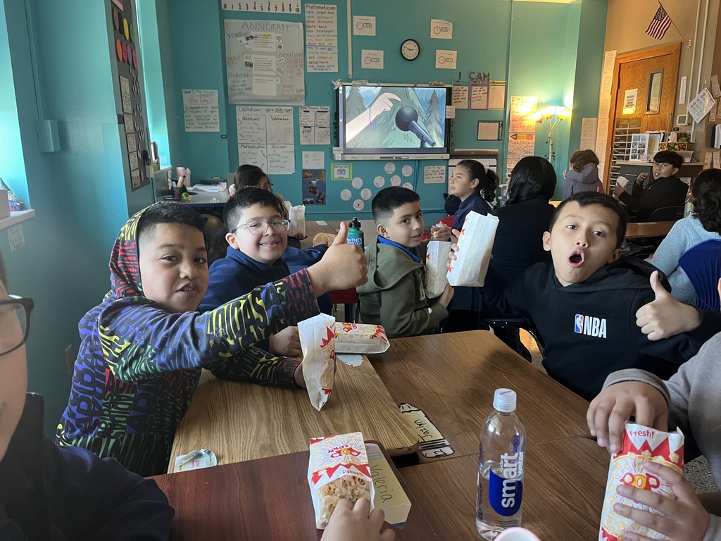 Children in their classroom eating popcorn — they won Best Attendance!