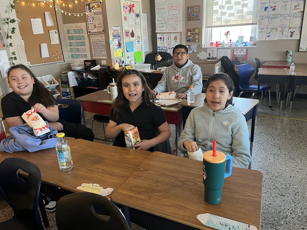 Children in their classroom eating popcorn — they were among the classes with the best attendance and received a popcorn party