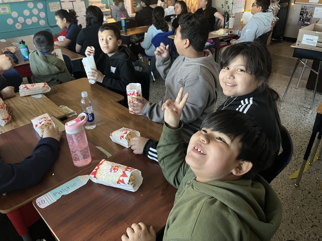 Children in their classroom eating popcorn — they were among the classes with the best attendance and received a popcorn party.