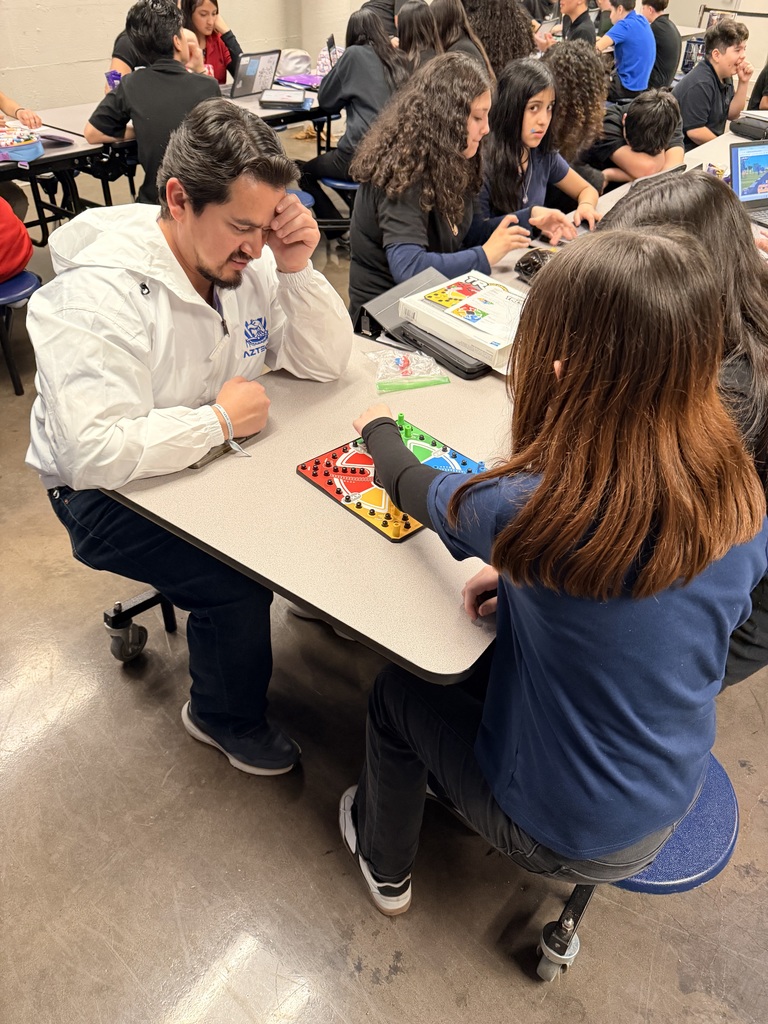 Mr. Posada playing board games with students