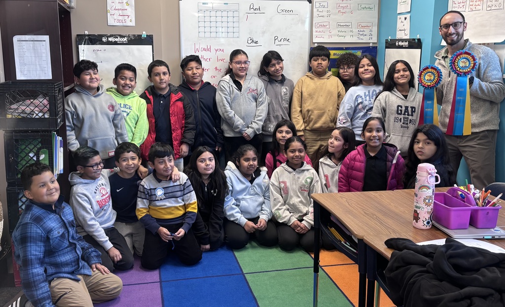 4th grade classroom posing with ribbon
