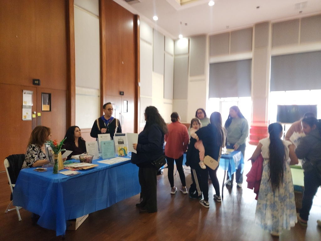 People gather around table for information