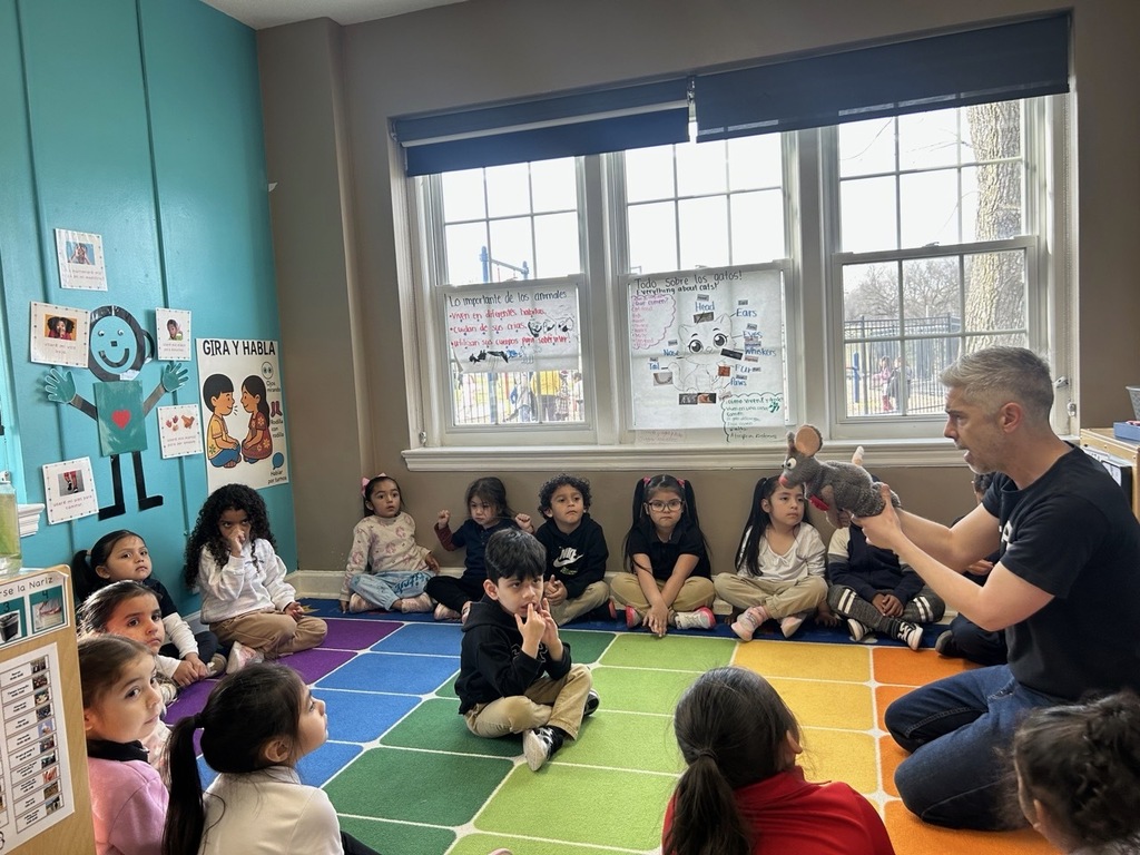Children sitting and enjoying a fun activity with a mouse puppet