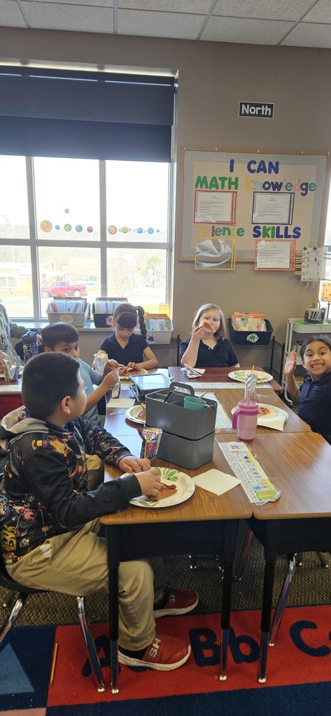 Students sitting, eating pizza and enjoying a conversation