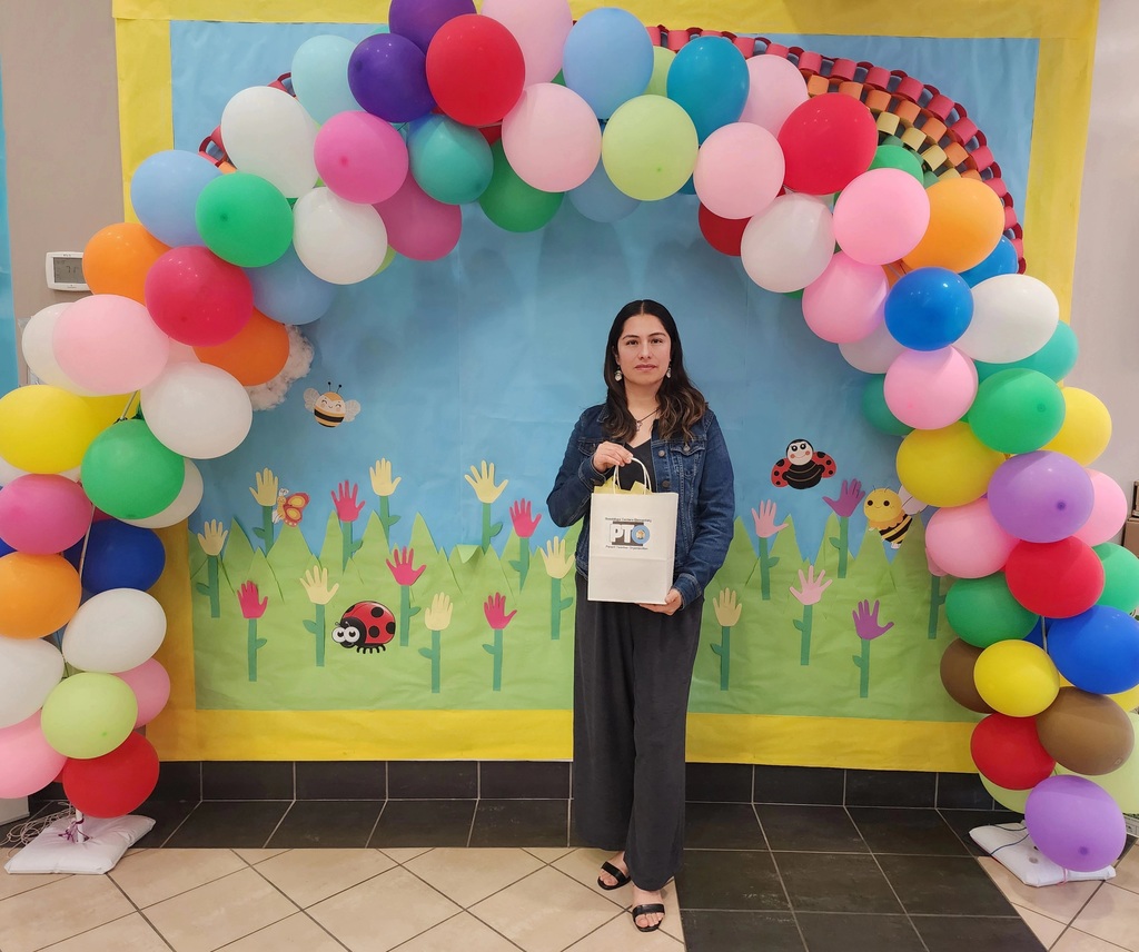 A woman with a gift bag; she is a Family Engagement (FACE) coordinator at an elementary school.