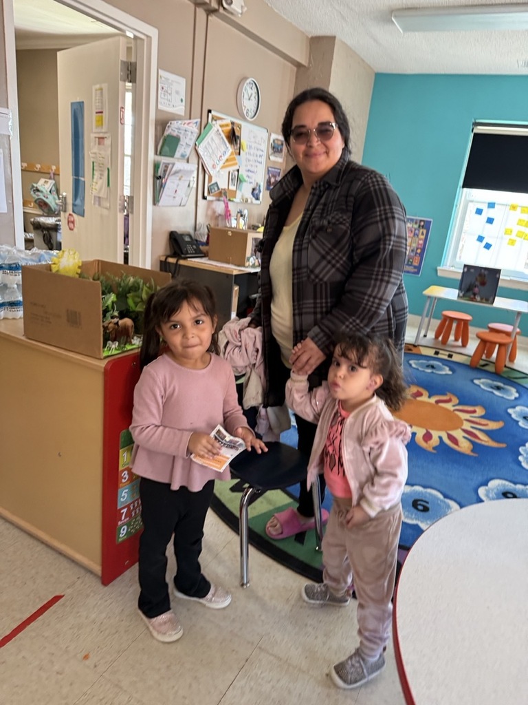 A Pre-K student with her mom. The student gave a demonstration for their family, explaining about animals and their habitat.