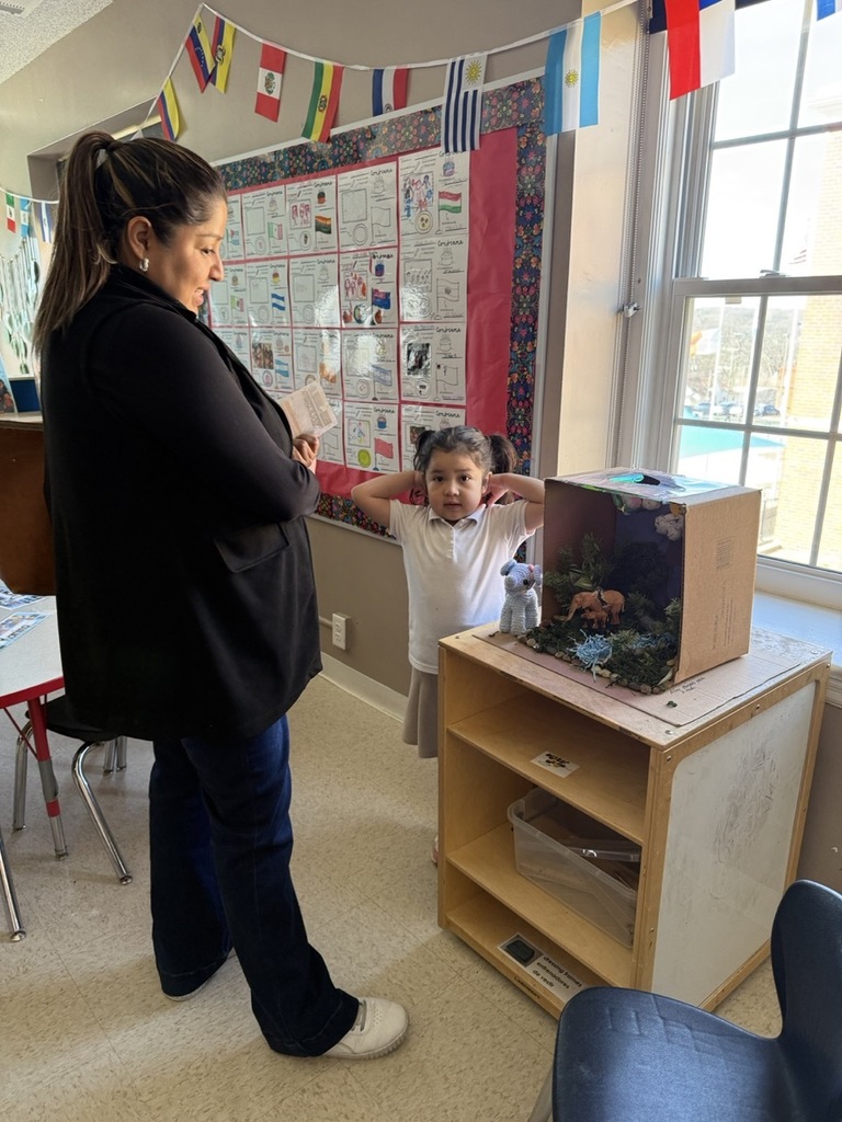 A Pre-K student with her mom. The student gave a demonstration for their family, explaining about animals and their habitat.