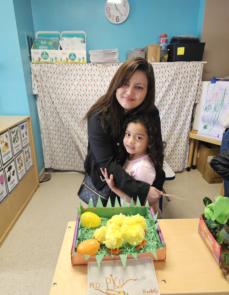 A Pre-K student with her mom. The student gave a demonstration for their family, explaining about animals and their habitat.