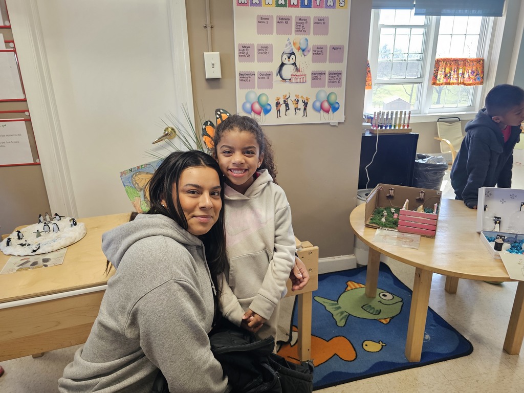 A Pre-K student with her mom. The student gave a demonstration for their family, explaining about animals and their habitat.