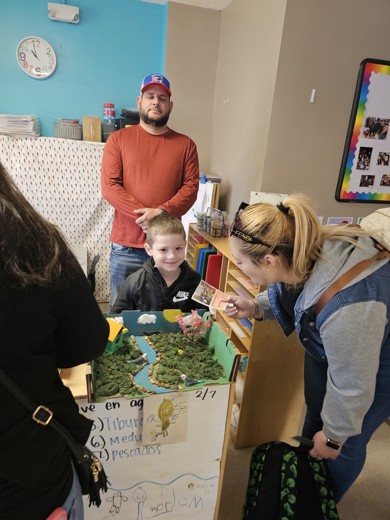 A Pre-K student with his mom. The student gave a demonstration for their family, explaining about animals and their habitat.