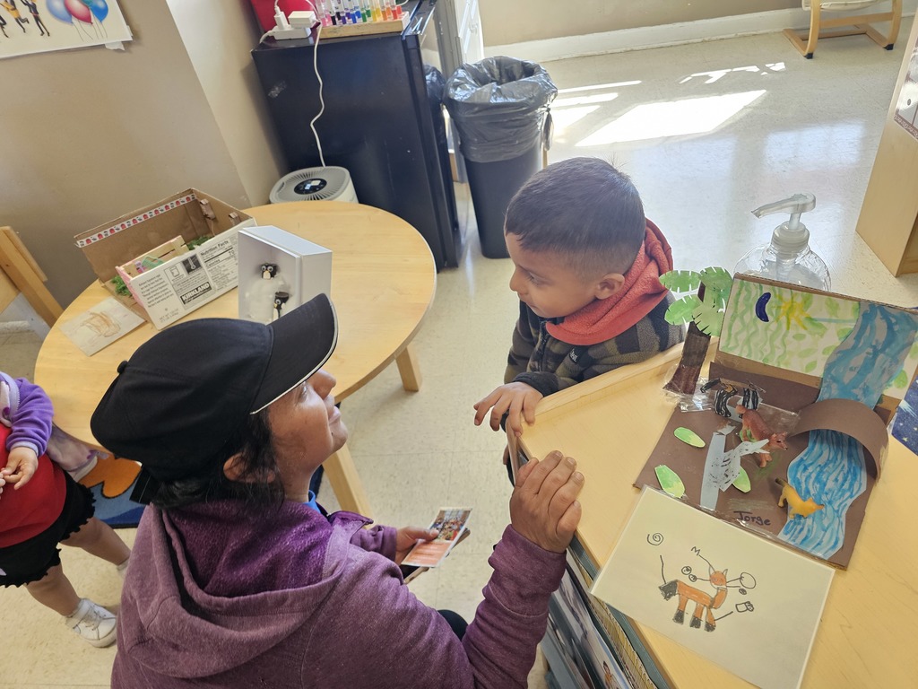A Pre-K student with his mom. The student gave a demonstration for their family, explaining about animals and their habitat.