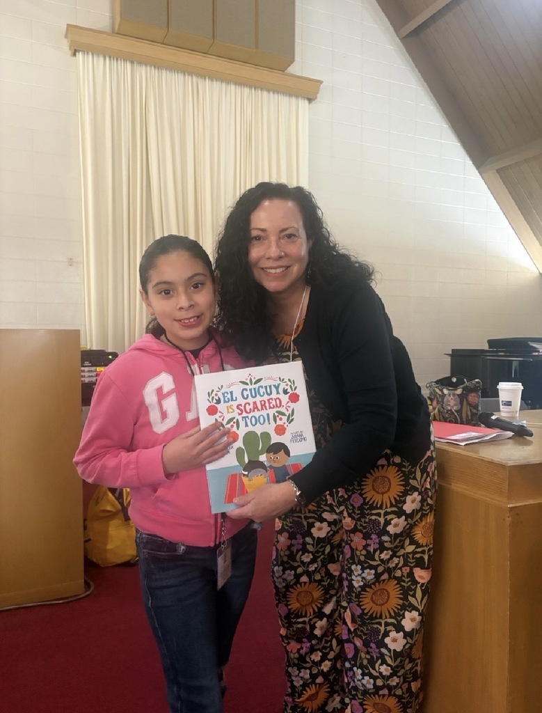 A girl posing for a photo with a well-known book author.