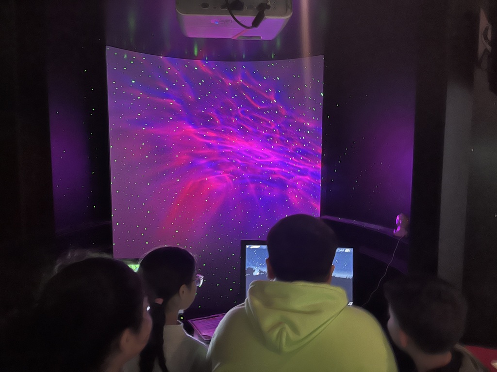 4 students looking at constellations in a screen 