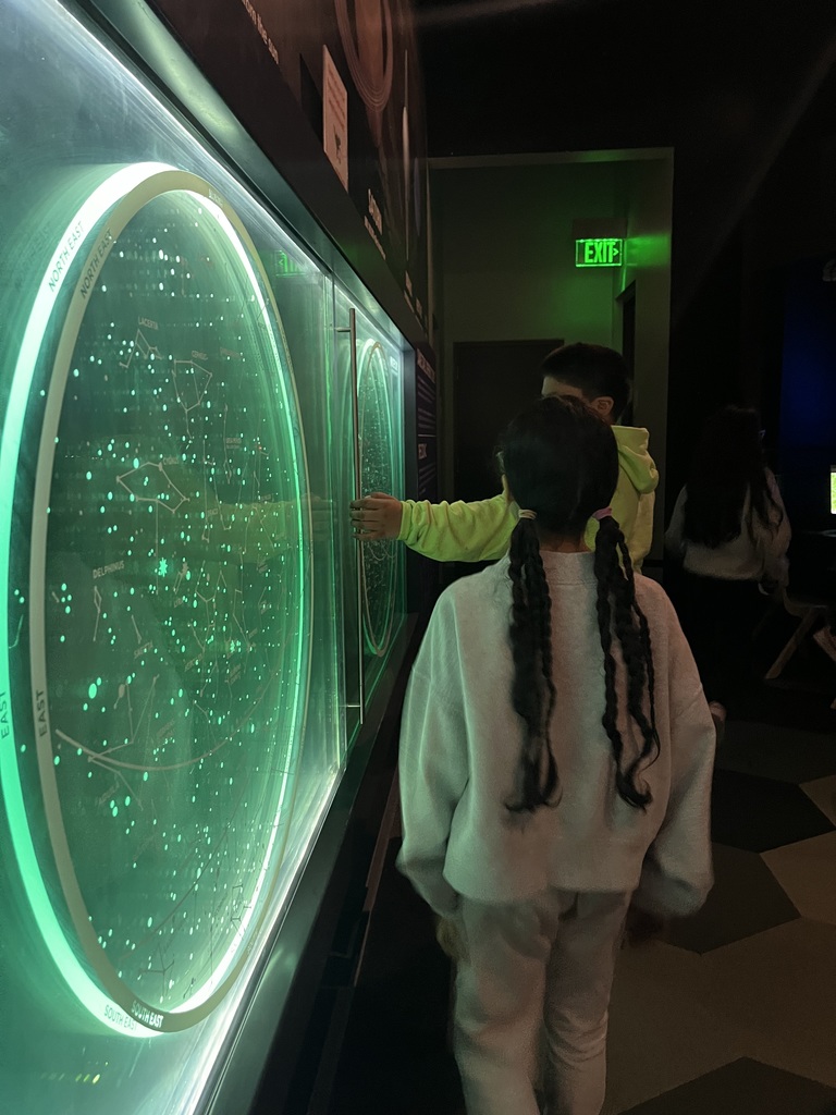Students looking at  constellations in the Prairiefire Museum 