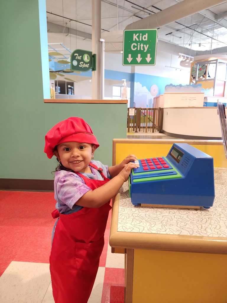 Child pretending to be a cashier, building imagination and social skills