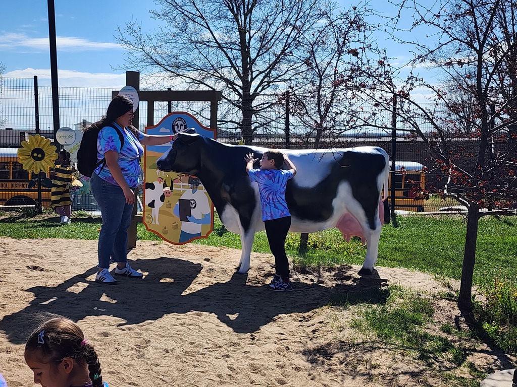 Teacher and Pre-K student standing next to a cow sculpture in a museum