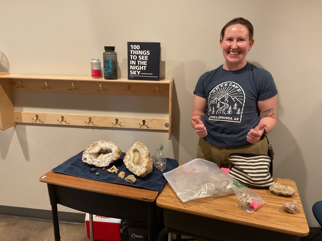 person posing with rocks and  precious rocks and metals.