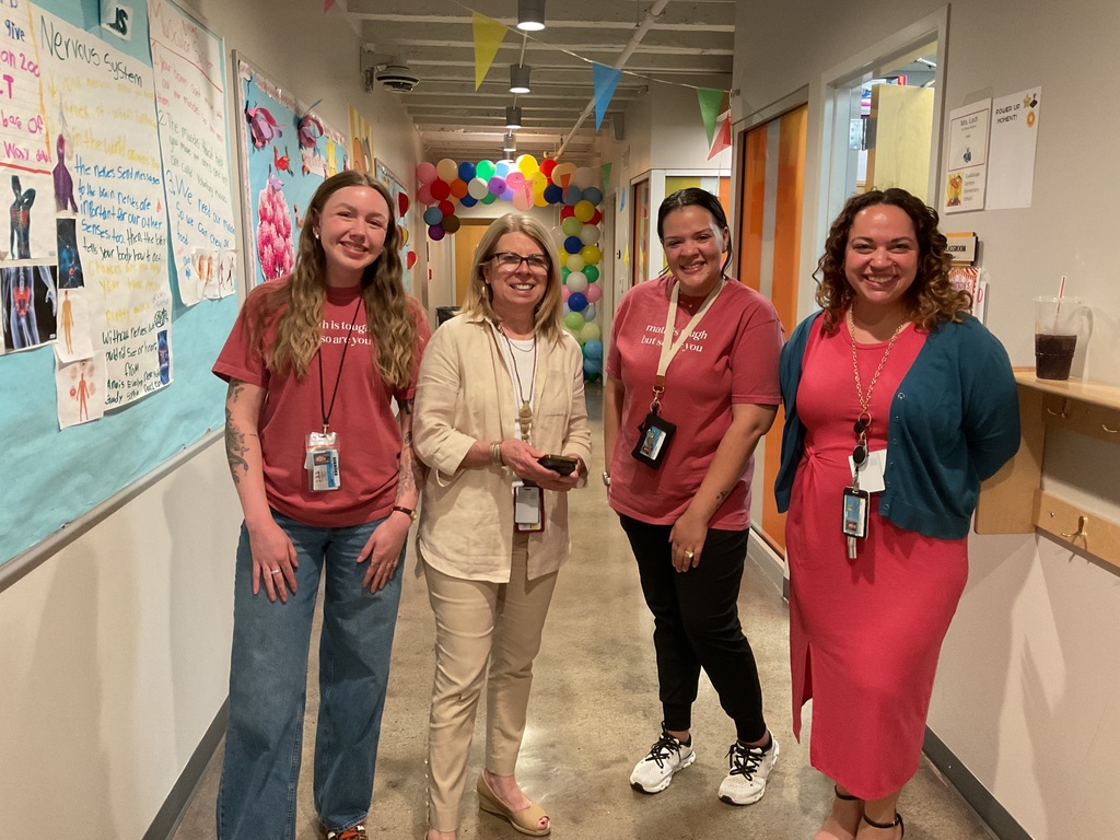 4 people standing on the hallway posing for the camera