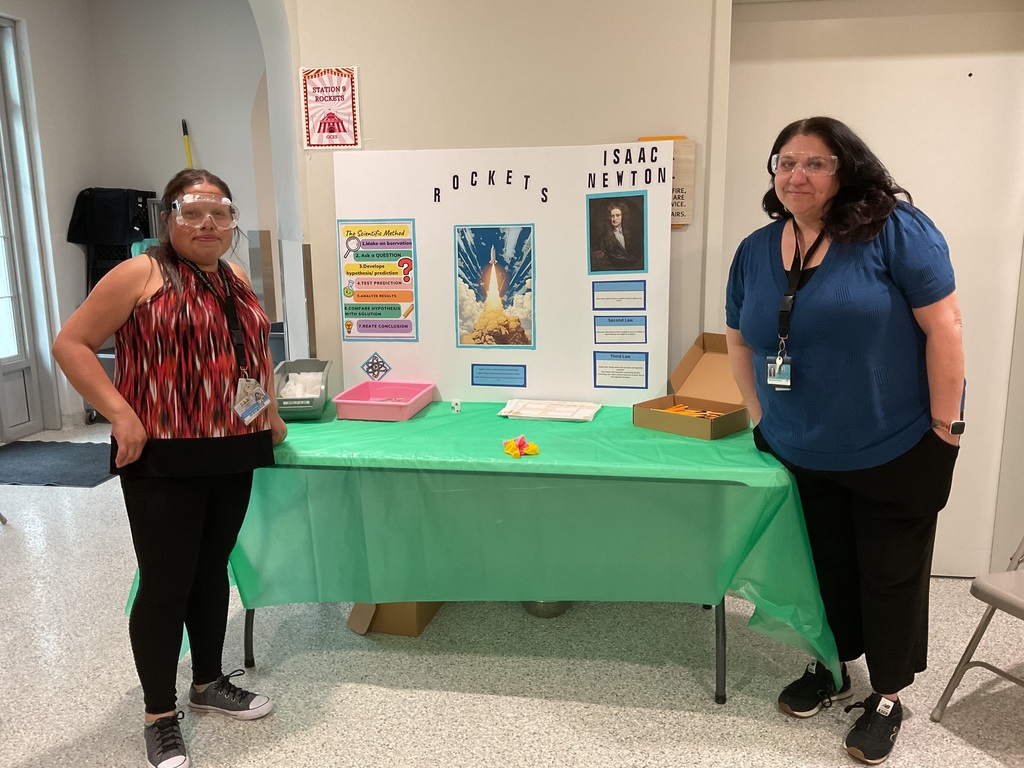2 people by a table with a rocket project 