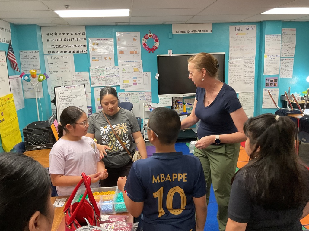 Teacher in a classroom surrounded by students. 