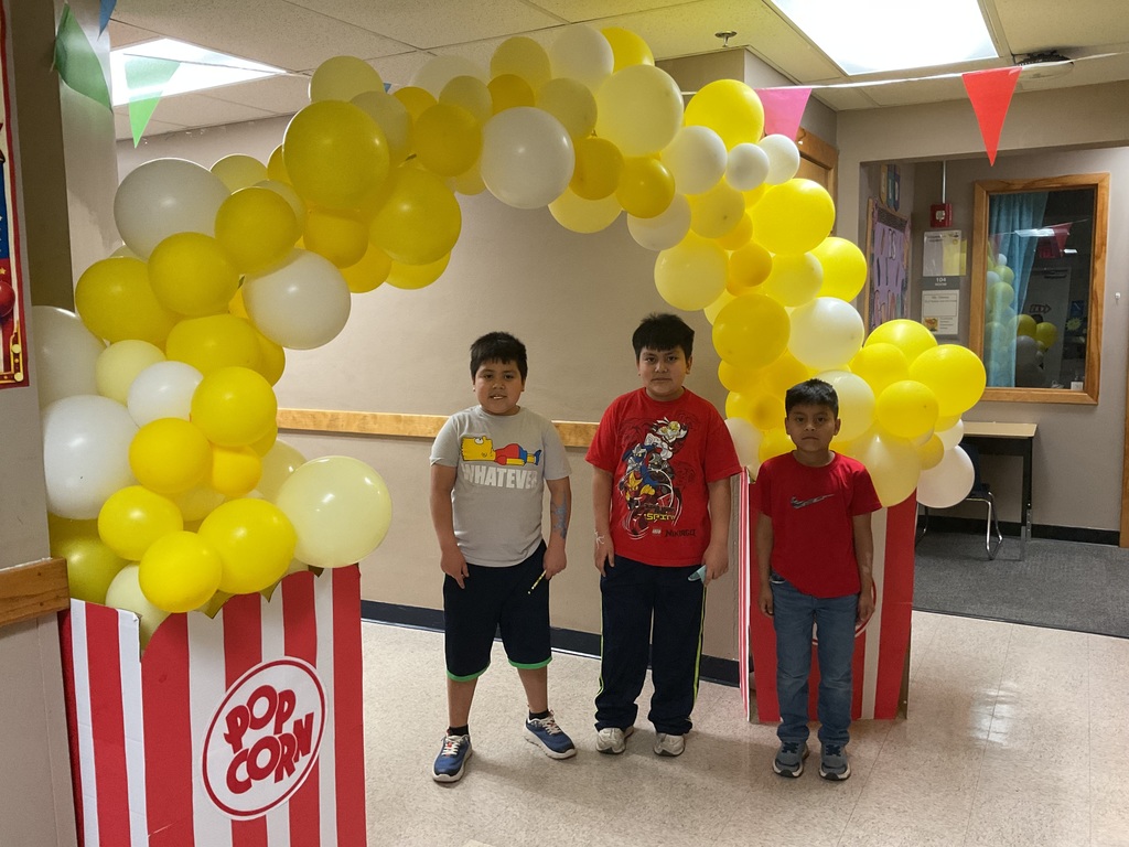 Kids under popcorn ballon arch