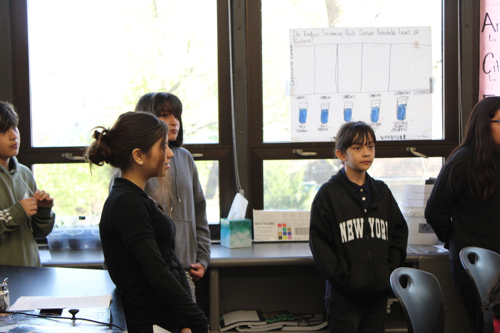 Students observing and standing in a classroom 