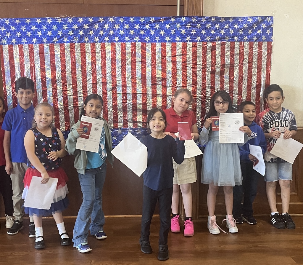 8 students wearing red, white and blue with an american flag background. 