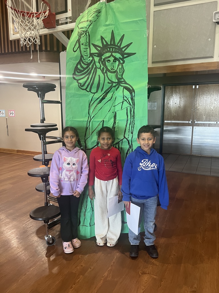 3 students with the statue of liberty background 