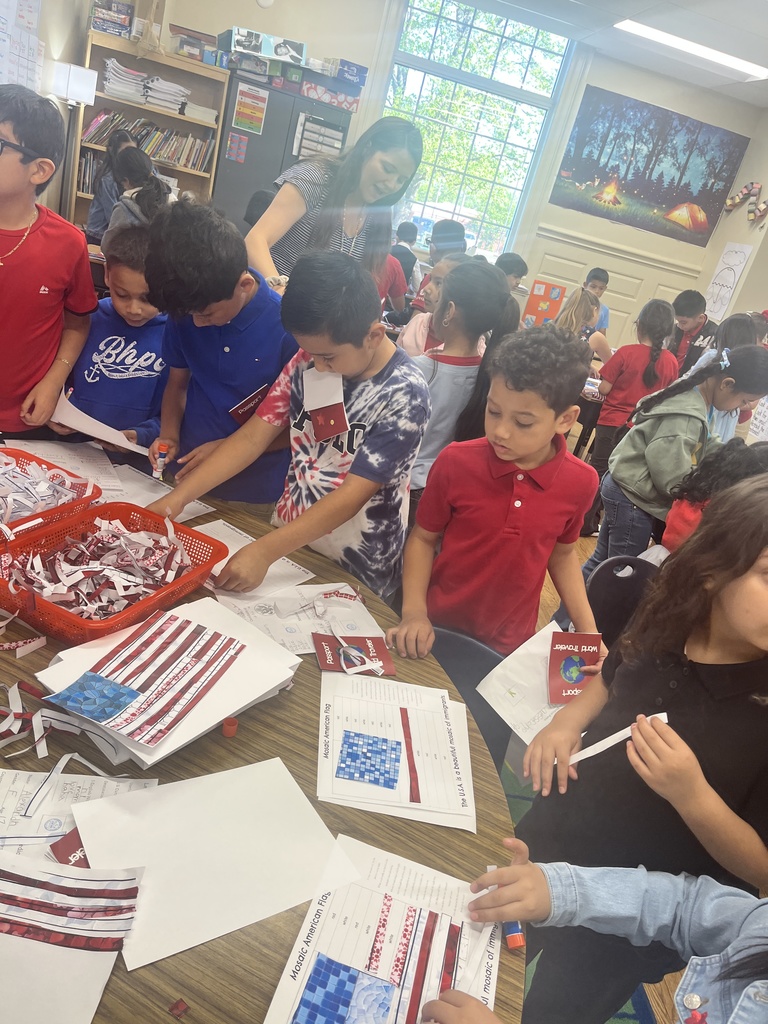 A group of students working on paper with the American Flag
