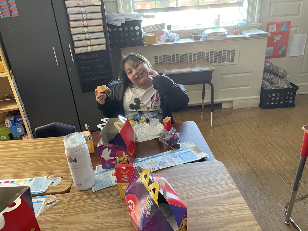 One student eating a happy meal and posing for the camera