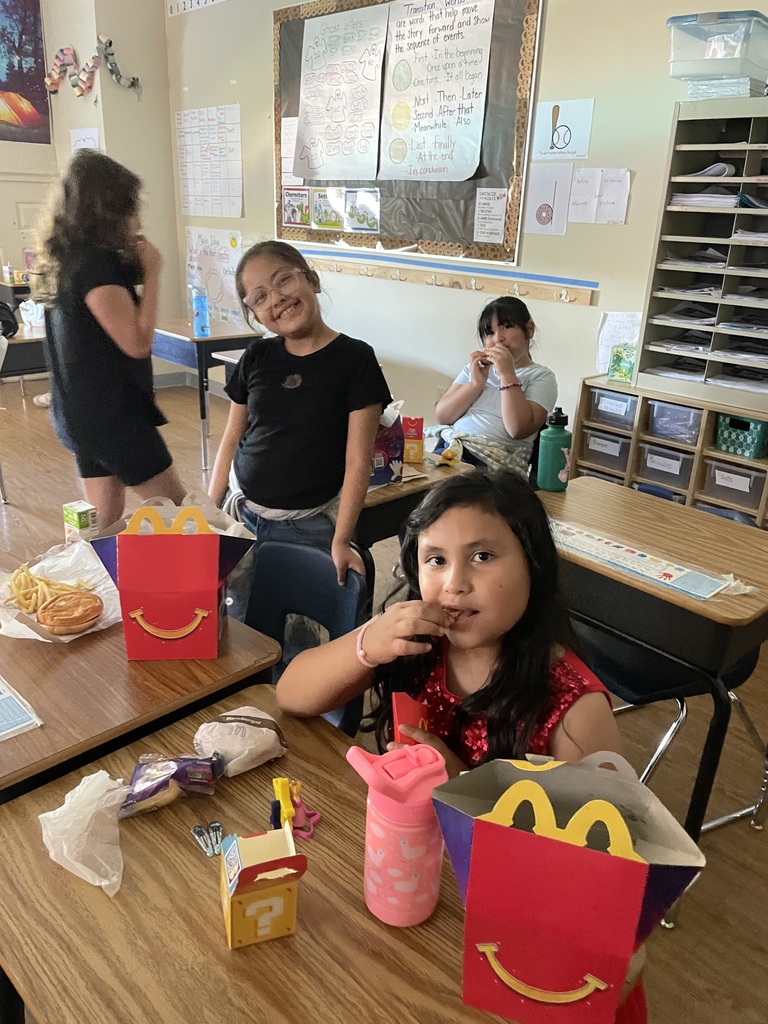 4 students eating their happy meal and smiling
