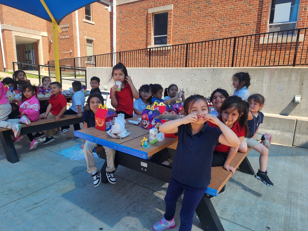 A group of students eating outdoors a happy meal.