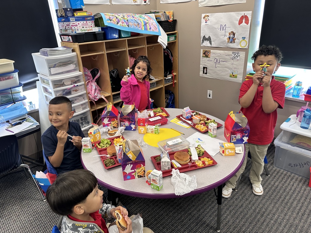 A group of students eating a happy meal and showing off the toys.