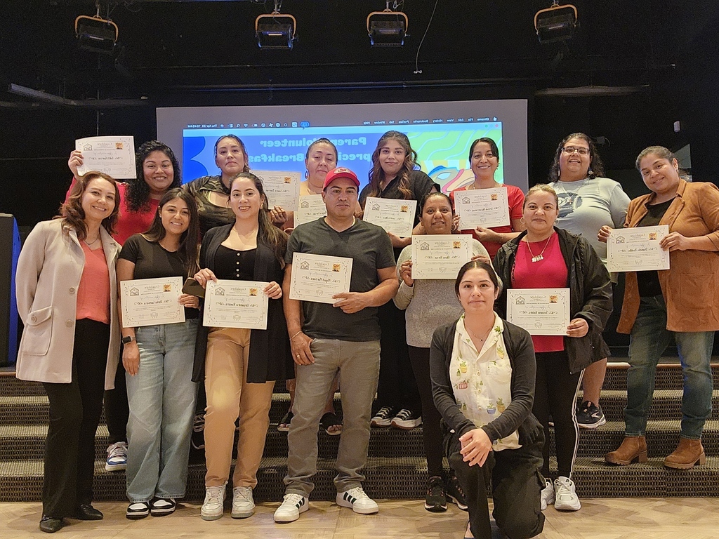 A group of adults posing holding a certificate