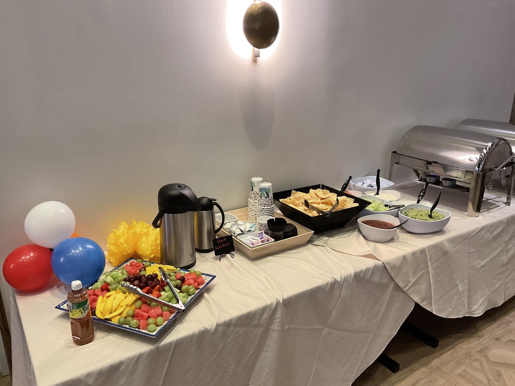 Rectangular table with food tray, chips, salsa.