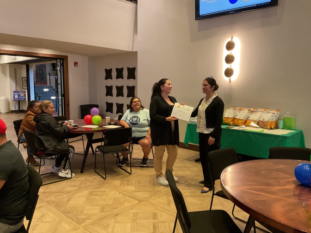 A woman handing a certificate to another