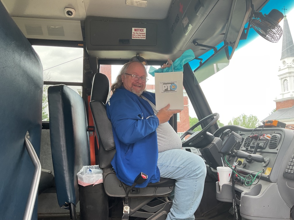 A male school bus driver with gift