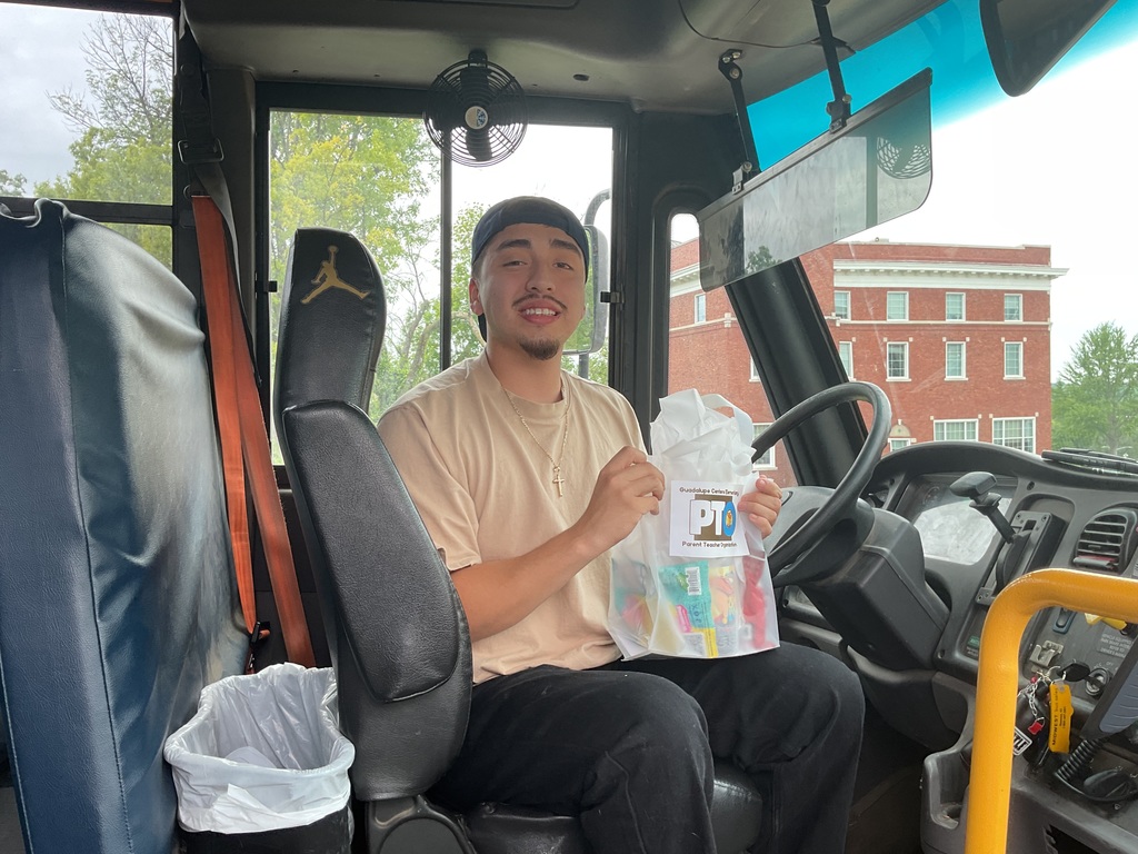 A male school bus driver with gift