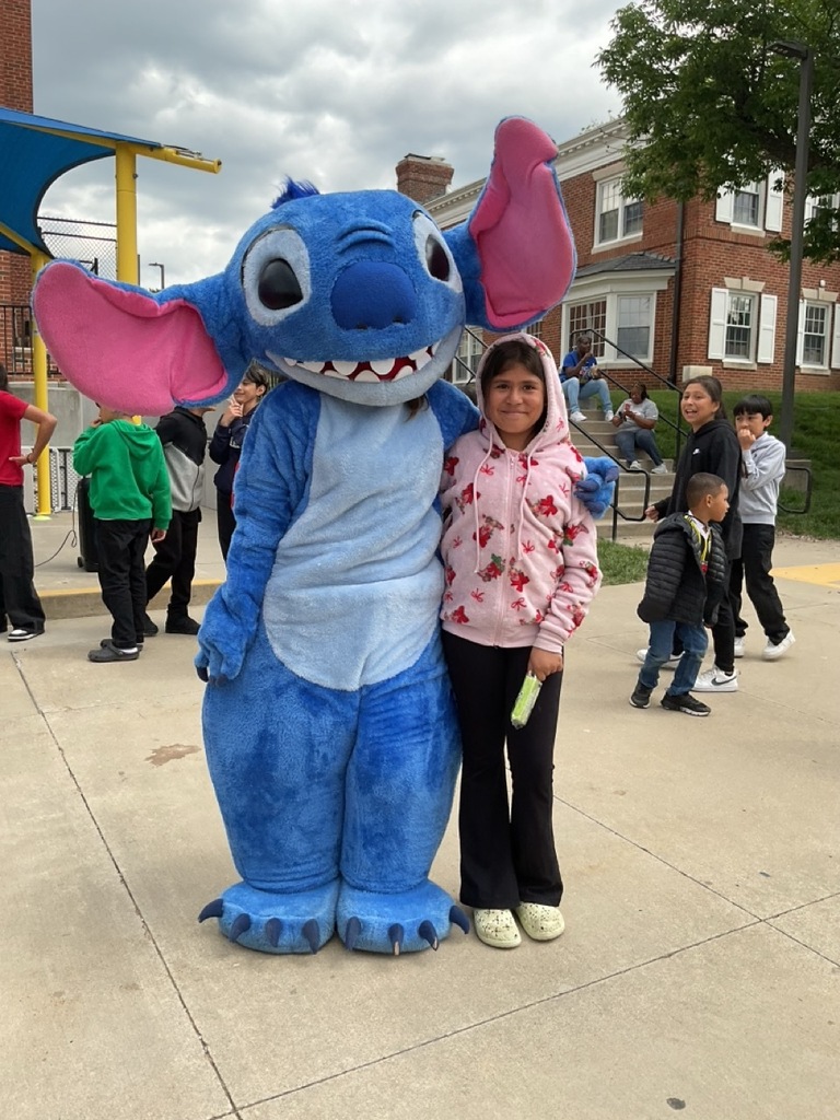 titch character hugging a little girl during the Children’s Day celebration at a school.