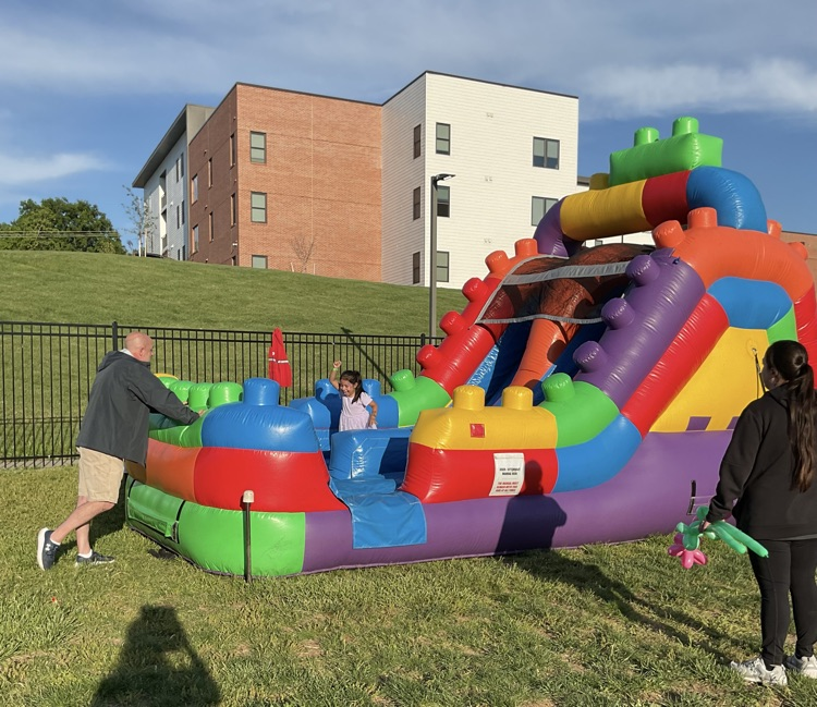 colorful inflatable castle kids coming out of it 