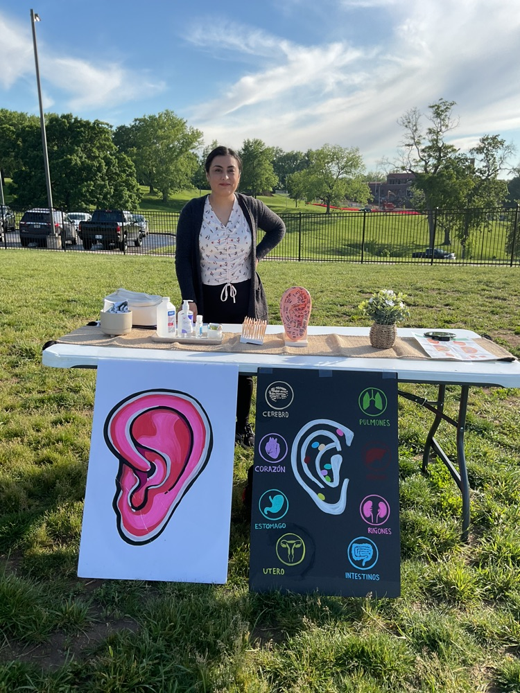a table with one person showing a picture of an ear 
