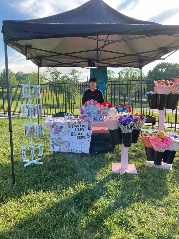 a stand selling flowers and pens 
