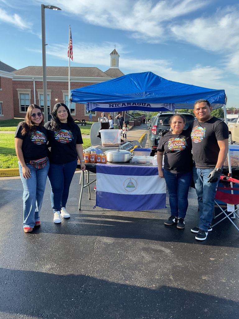 4 people posing with a table and the nicaraguan flag