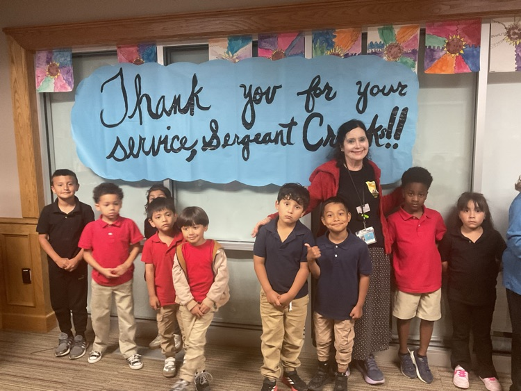 group of students under a sign that reads thank you for your service officer crooks
