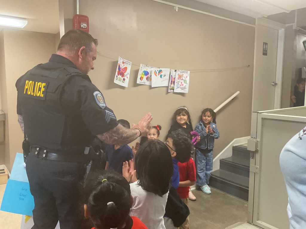 Group of students high fiving the officer