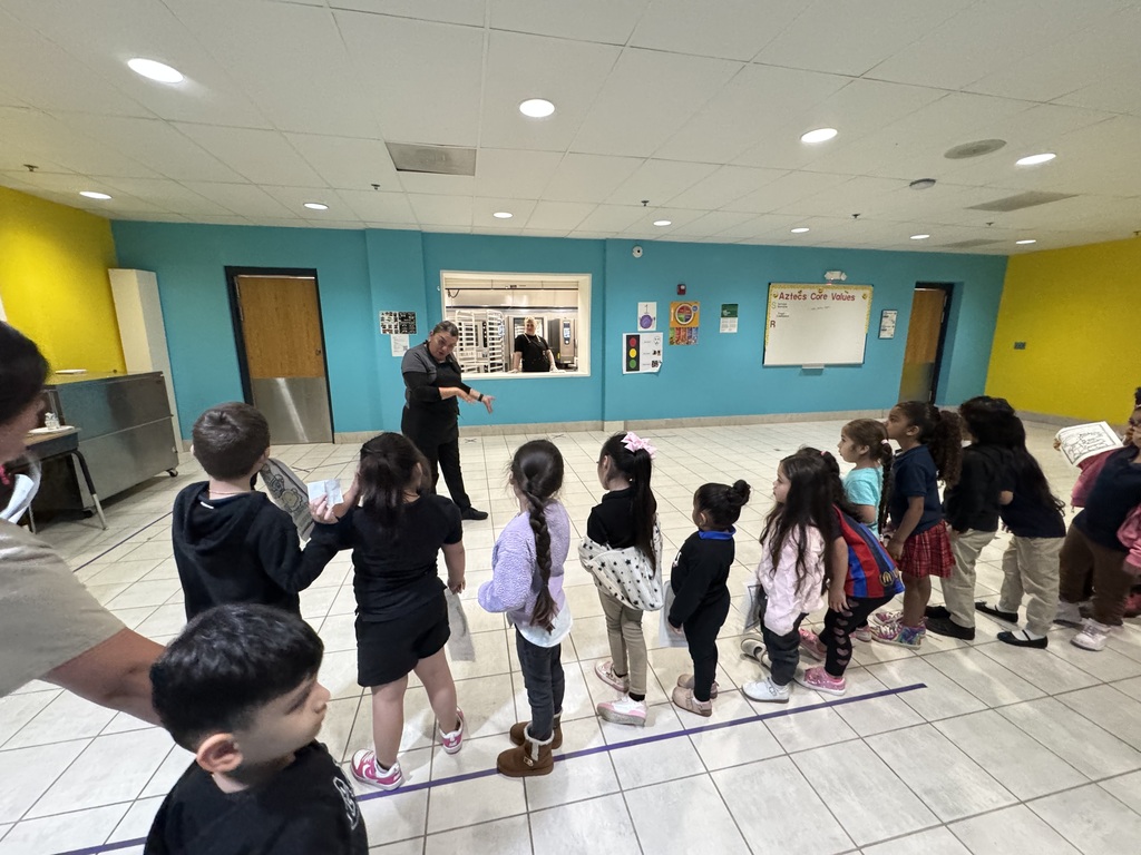 Students in the cafeteria line up an adult in front of them