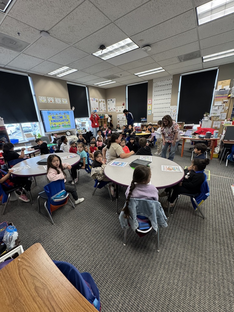 Students sitting on round tables in a classroom.